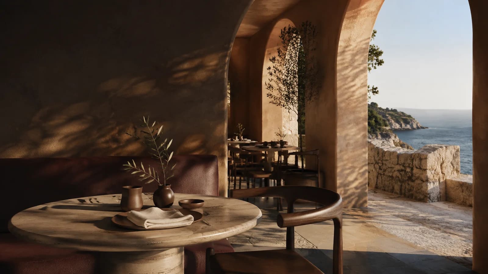Sun-warmed stone arches framing the Mediterranean and intimate dining tables at Sera